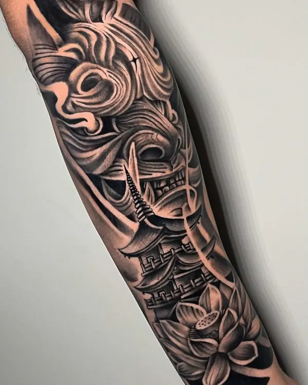 Antebraço fechado em black and grey com máscara de samurai, pagode e flor de lótus